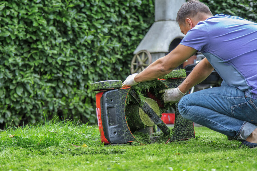 Man checking sharpness of lawn mower blade